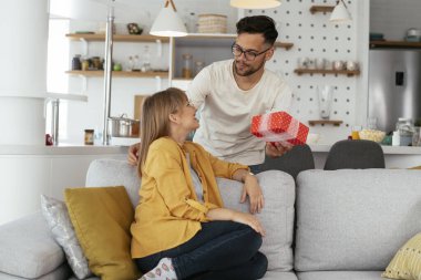 Erkek arkadaşı kız arkadaşına hediyeyle sürpriz yapıyor. Genç adam karısına hediye kutusu veriyor.