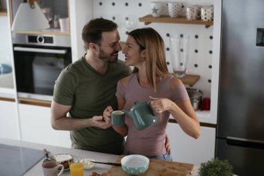 Çift evde birlikte yemek pişiriyor ve yemek hazırlıyor.