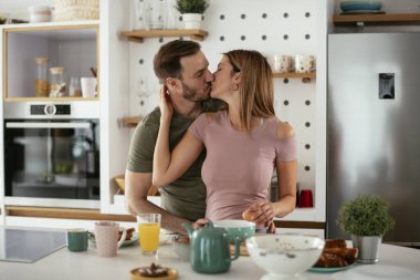 Çift evde birlikte yemek pişiriyor ve yemek hazırlıyor.