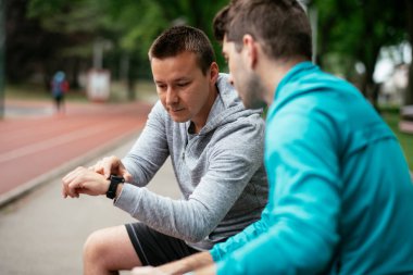 Koşmaktan istirahat eden zinde genç adamlar. Dışarıda antrenman yapan iki arkadaş..