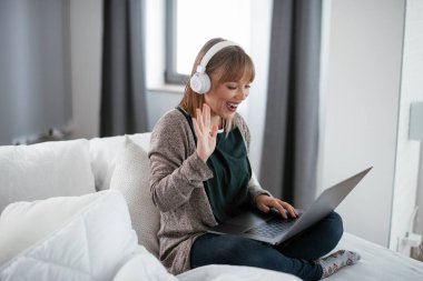 Güzel bir kadın görüntülü görüşme yapıyor. Güzel kadın evde eğleniyor..