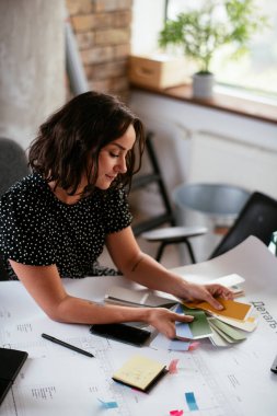 Ofiste yeni projeler üzerinde çalışan genç ve güzel bir iş kadını.