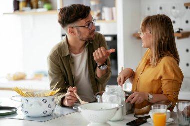 Karı koca mutfakta. Genç çift evde lezzetli yemekler hazırlıyor..