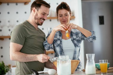 Çift evde birlikte yemek pişiriyor ve yemek hazırlıyor.