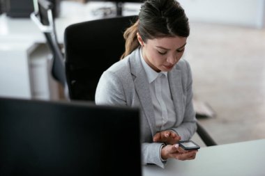 Ofiste dijital glukometre kullanan güzel bir iş kadını. Genç bir kadın kan şekerini ölçüyor.