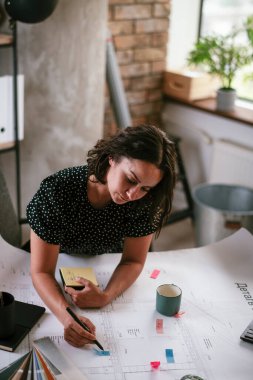 Ofiste yeni projeler üzerinde çalışan genç ve güzel bir iş kadını.