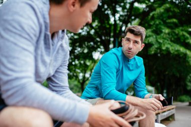 Koşmaktan istirahat eden zinde genç adamlar. Dışarıda antrenman yapan iki arkadaş..