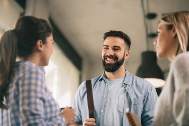 Modern açık uzay ofisinde sıradan iş adamlarından oluşan bir grup. İş kadınları ve işadamları yeni proje hakkında konuşuyor.