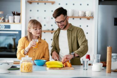 Karı koca mutfakta. Genç çift evde lezzetli yemekler hazırlıyor..