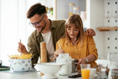 Karı koca mutfakta. Genç çift evde lezzetli yemekler hazırlıyor..