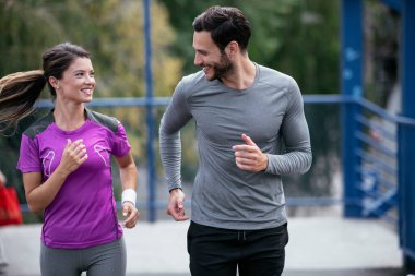 Atletik çift şehirde koşuyor. Mutlu çift dışarıda antrenman yapıyor..