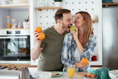 Mutfakta taze meyveleri olan mutlu çift.