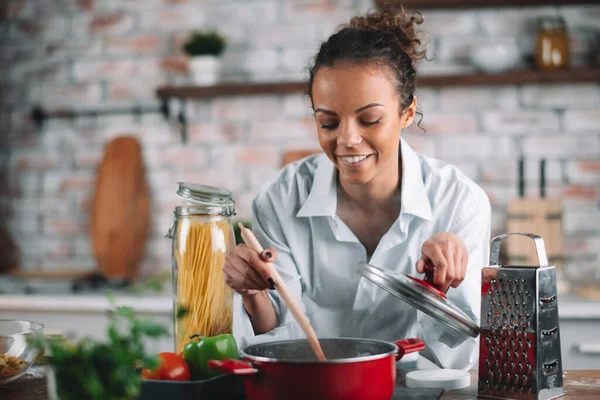 Güzel bir kadın yemek pişiriyor ve mutfakta eğleniyor. Kız mutfakta sağlıklı yemek pişiriyor..