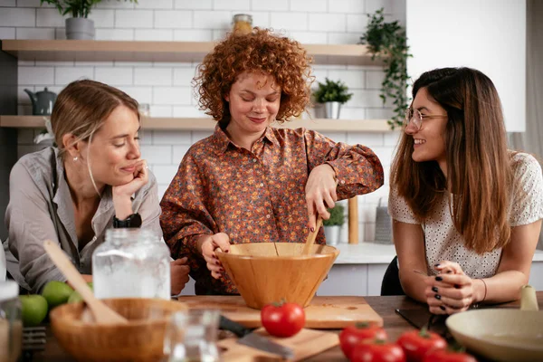 Women friends having fun in kitchen. Sisters cooking together.