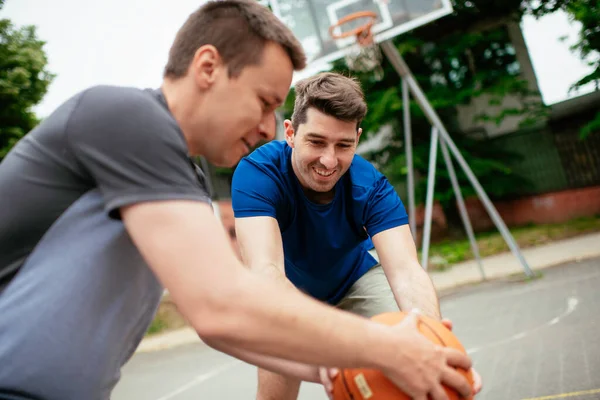 公園でバスケットボールをしている二人の若者 屋外で友好的な試合をしている友人 — ストック写真