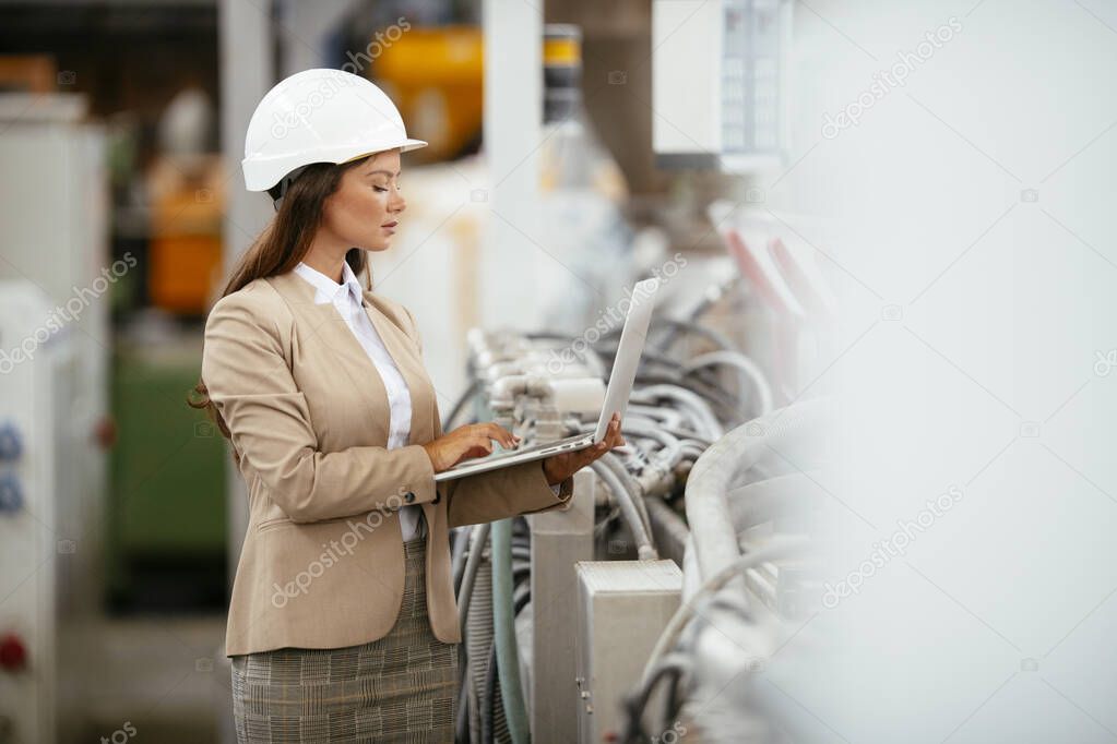 Factory manager in inspection of manufacturing. Woman in industrial environment.