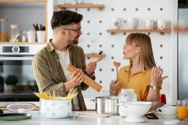 Karı koca mutfakta. Genç çift evde lezzetli yemekler hazırlıyor..
