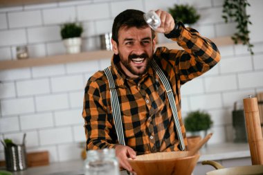 Mutfaktaki yakışıklı adamın portresi. Genç adam lezzetli yemekler hazırlıyor..