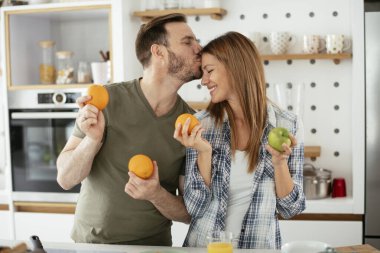 Mutfakta taze meyveleri olan mutlu çift.