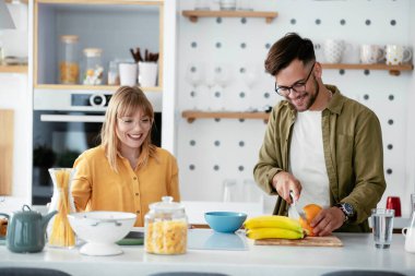 Karı koca mutfakta. Genç çift evde lezzetli yemekler hazırlıyor..