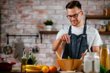 Mutfakta makarna hazırlayan yakışıklı adam. Lezzetli yemek pişiren adam..