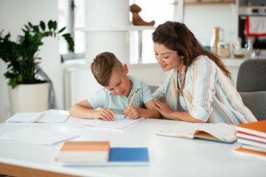 Anne oğluyla ödev yapıyor.