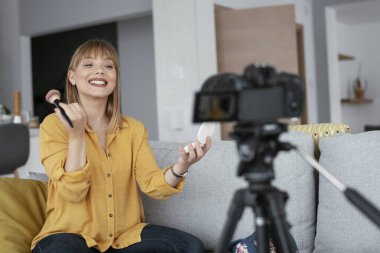Kadın video kaydedicisi, kanalı için makyaj dersi kaydediyor. Sosyal medyada paylaşmak için makyaj dersi alan genç ve güzel bir kadın..