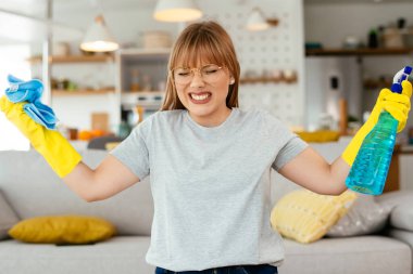 Evini temizleyen üzgün kadın. Evde yorgun bir kadın var..