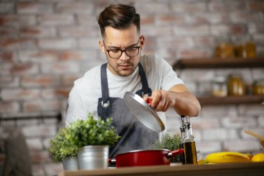 Mutfakta makarna hazırlayan yakışıklı adam. Lezzetli yemek pişiren adam..