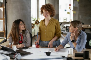 İş kadınları yeni bir proje üzerinde çalışıyor. İş arkadaşları ofiste iş tartışıyor.