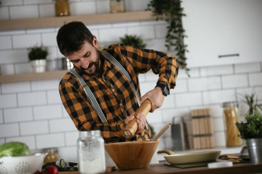 Mutfaktaki yakışıklı adamın portresi. Genç adam lezzetli yemekler hazırlıyor..