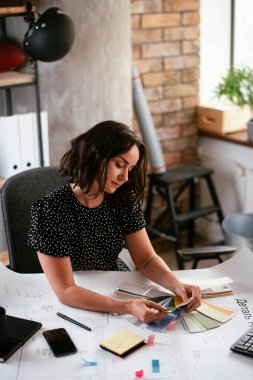 Ofiste yeni projeler üzerinde çalışan genç ve güzel bir iş kadını.