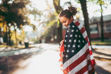 Amerikan bayrağı taşıyan genç bir kadın. 