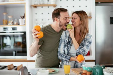 Mutfakta taze meyveleri olan mutlu çift.