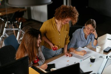 İş kadınları yeni bir proje üzerinde çalışıyor. İş arkadaşları ofiste iş tartışıyor.