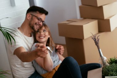 Yeni evde kutuların yanında kucaklaşan çift.