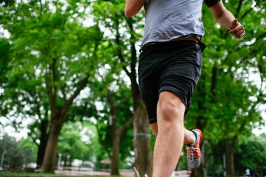 Genç adam yarış pistinde antrenman yapıyor. Adam atletizm pistinde koşuyor. 