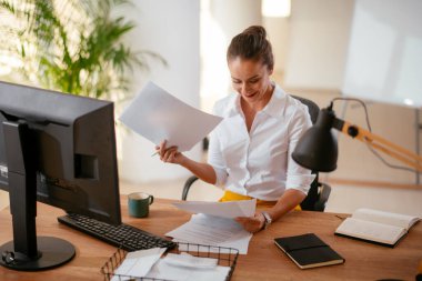 Ofiste çalışan kendinden emin genç bir iş kadını. 