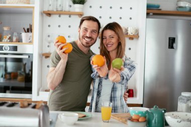 Mutfakta taze meyveleri olan mutlu çift.