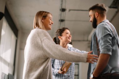 Modern açık uzay ofisinde sıradan iş adamları konuşuyor.. 