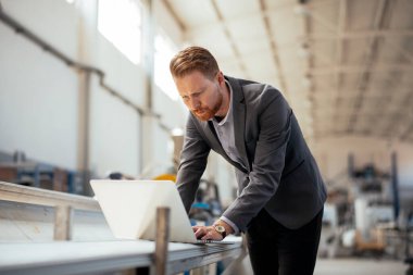 Fabrika müdürü imalat teftişinde. Endüstriyel çevredeki adam