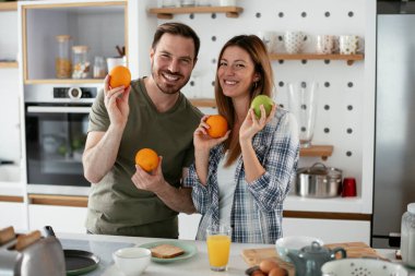 Mutfakta taze meyveleri olan mutlu çift.