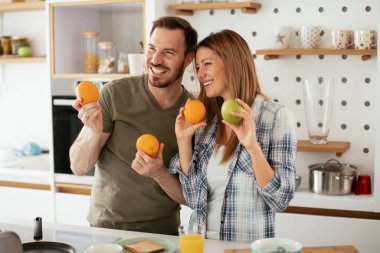 Mutfakta taze meyveleri olan mutlu çift.