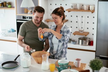 Çift evde birlikte yemek pişiriyor ve yemek hazırlıyor.