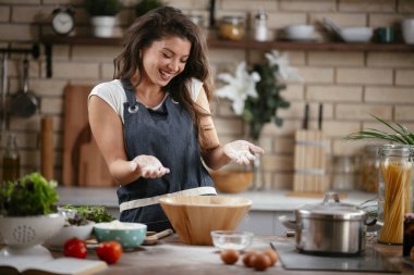 Mutfakta yemek yapan güzel genç bir kadının portresi. Genç Kadın Aşçılık. Sağlıklı Yemek - Sebze Salatası.