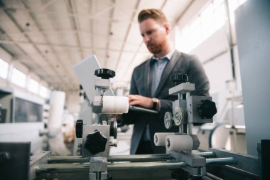 Fabrika müdürü imalat teftişinde. Endüstriyel çevredeki adam