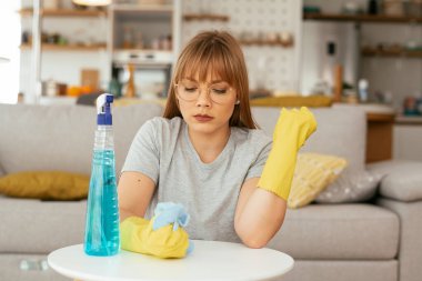 Evini temizleyen üzgün kadın. Evde yorgun bir kadın var..