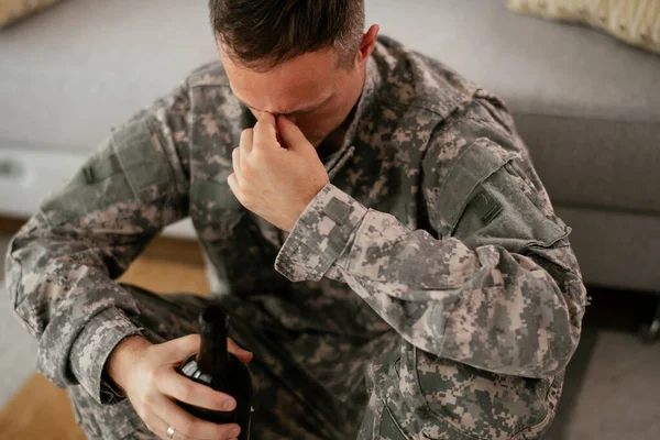 upset military man drinking alcohol at home