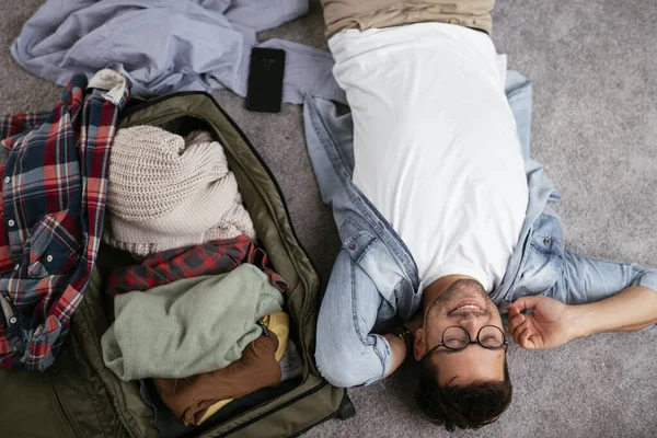 man getting ready for trip, packed bag