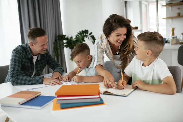 Ebeveynler çocuklara ev ödevlerinde yardım ediyorlar. Küçük çocuklar evde öğreniyor..